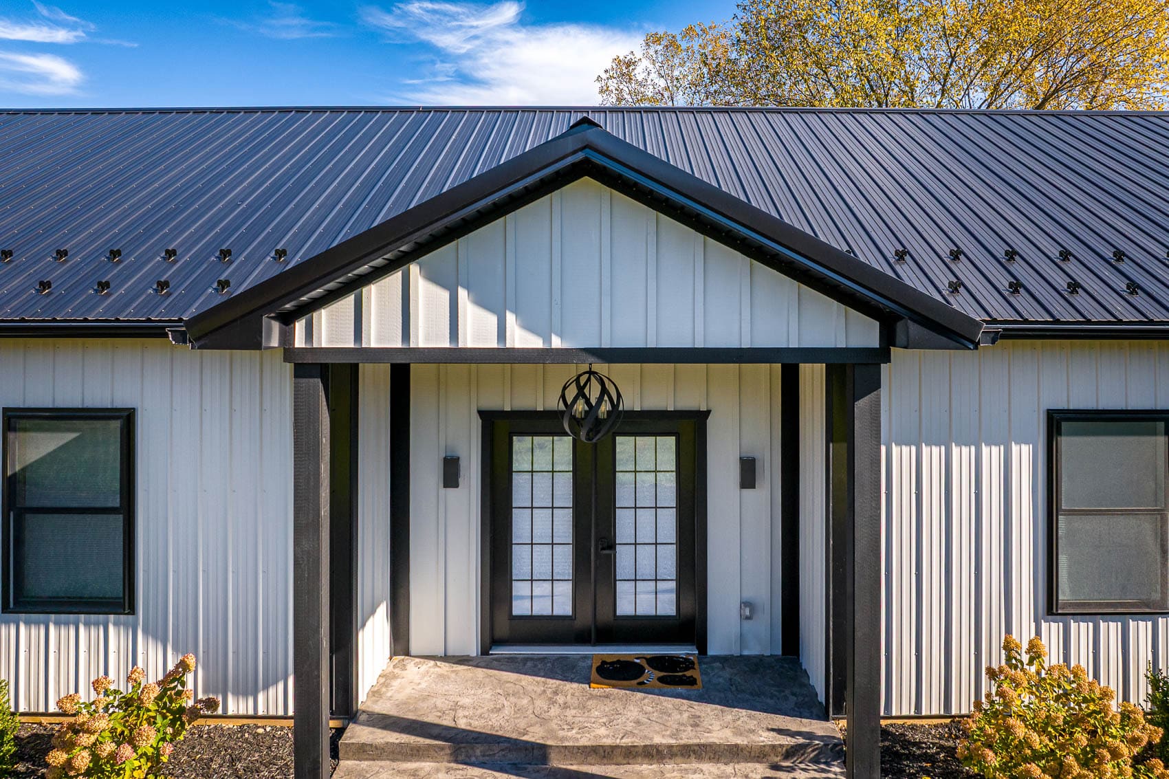 Close entry detail of white barndominium with black metal roof